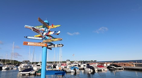 Signpost at the marina with signs pointing in all directions