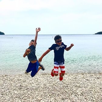 Two kids jumping for joy on a beach