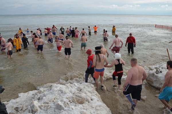 People rushing into the lake at the Polar Plunge