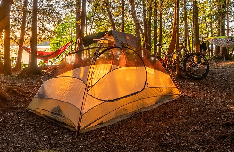A tent set up for camping in the woods