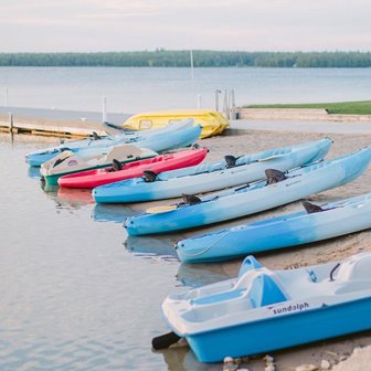 A line of kayaks docked on the beach