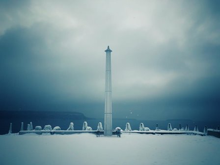 Monument on a snow-covered overlook of the lake