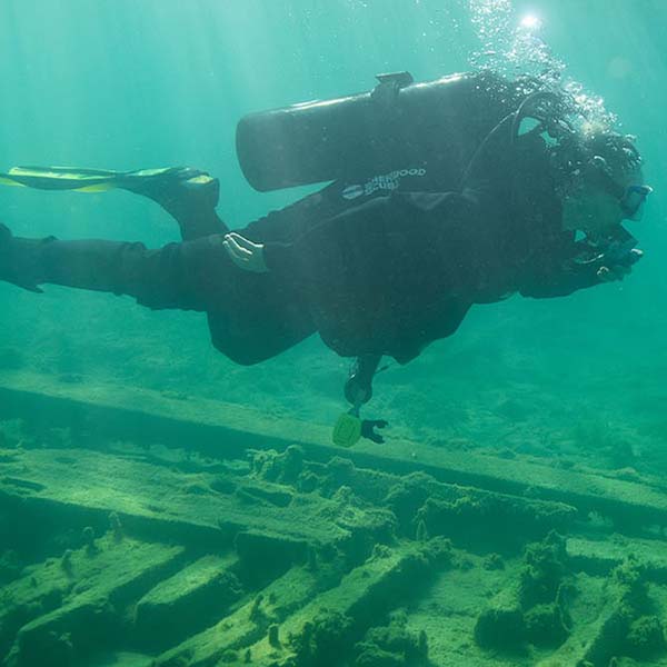 A scuba diver by a shipwreck