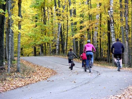 Family biking through the woods in Potawatomi State Park.