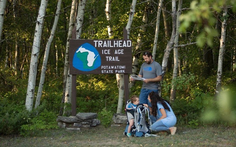 A couple and their baby at the Ice Age Trail trailhead.