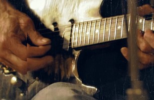 Closeup of someone playing an electric guitar.