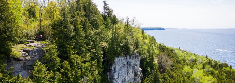 An escarpment lined with trees and the lake in the distance.