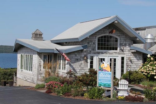 The coastal-style Shoreline Restaurant exterior with a sweeping lake view in the background.