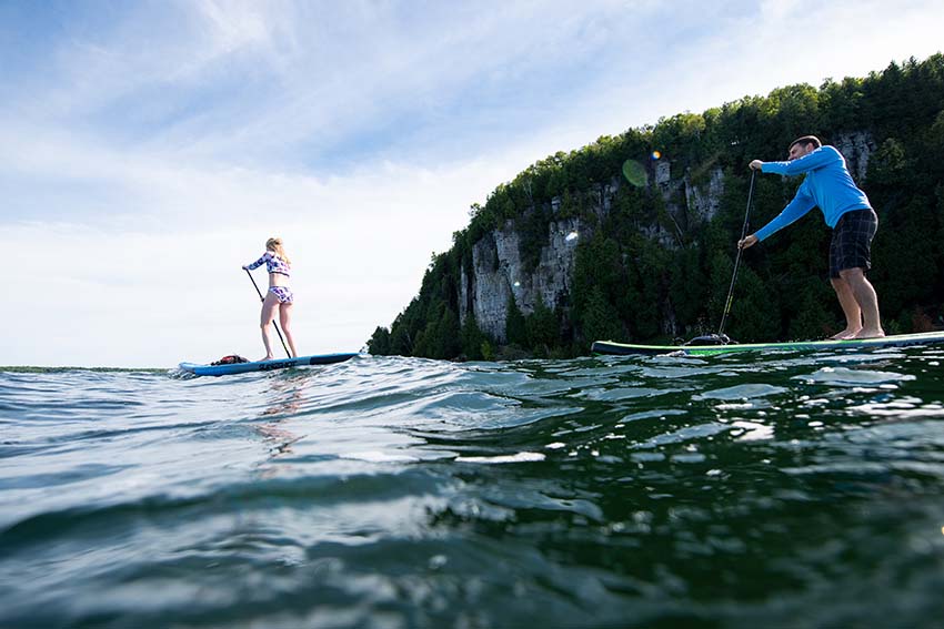 A couple stand-up paddle boarding