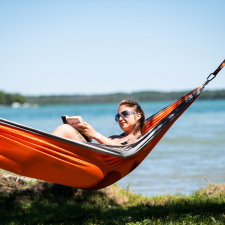 Woman relaxing and reading in a hammock.