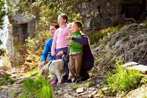 A family of four with their dog takes in the views from Eagle Trail in Peninsula State Park with a towering rock wall behind them.