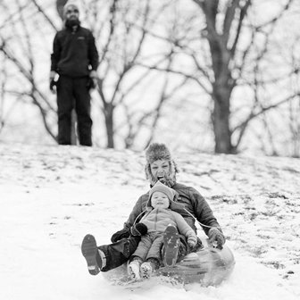 A family snowtubing down a hill.