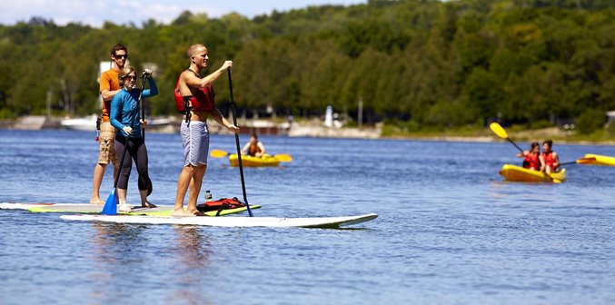 People standup paddle boarding and kayaking on the lake.