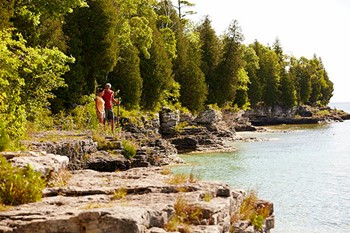 Couple hiking along the lakefront at Cave Point