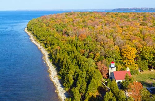 Aerial view of Eagle Bluff lighthouse among vibrant fall colors.
