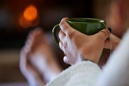 A woman relaxes with hot tea at a spa.