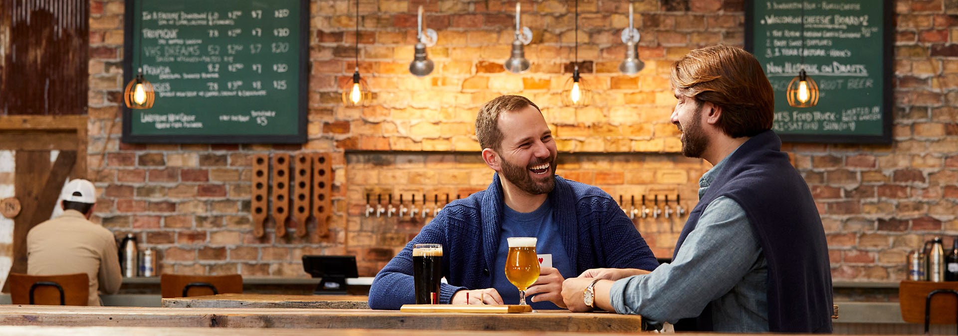 Two men laughing and drinking beer.
