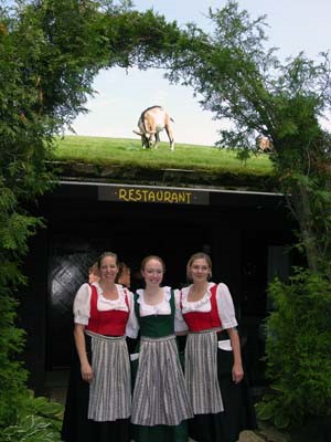 Servers at Al Johnson's wear traditional Swedish dresses and pose beneath the roof goats.