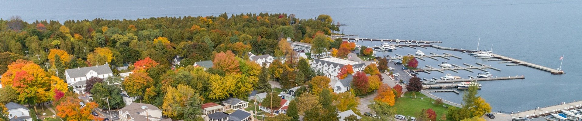 A town and marina surrounded by trees in their fall colors