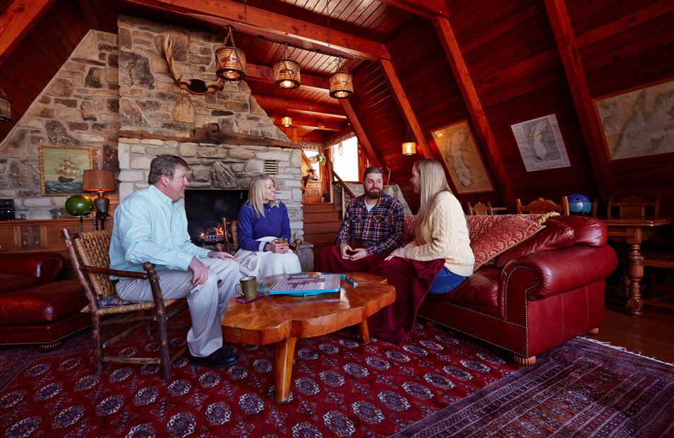 Two couples sitting and talking in a cabin.