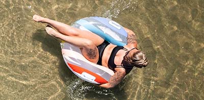 Aerial view of a woman in a tube on the lake.