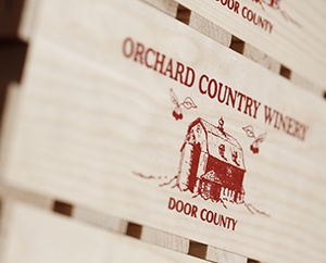 Crates with Orchard County Winery printed on them in red.