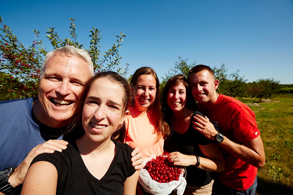 A group posing for a photo in a cherry orchard