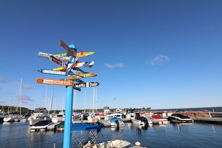 A signpost with signs pointing in all directions at the Egg Harbor Marina.