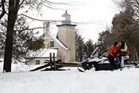 Snowmobilers near the lighthouse in Peninsula State Park.