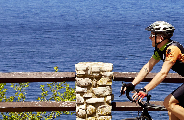 A man biking past the lake.