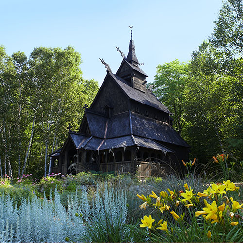 Stavkirke building among trees and flowers
