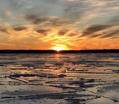 The sun setting over the frozen lake.