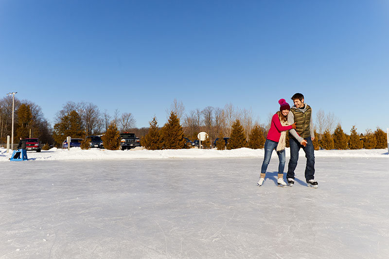 A couple ice skating on a lake on a sunny day