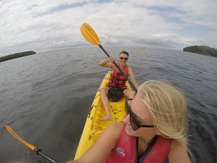 A man and woman on a kayak on the lake.