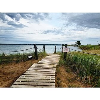 A boardwalk leading out to the lake on a cloudy day.