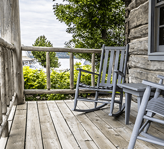 Two rocking chairs on a wooden porch.