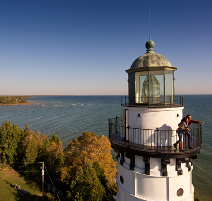 Top of a lighthouse with trees and the lake in the background