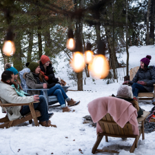 People bundled up and sitting in chairs in the snow