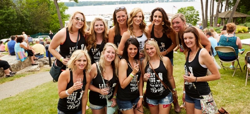 Eleven women at a bachelorette party with matching shirts posing for the camera