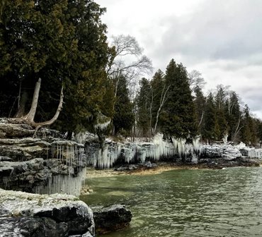 Icicles hanging off of rocks at the lakefront.