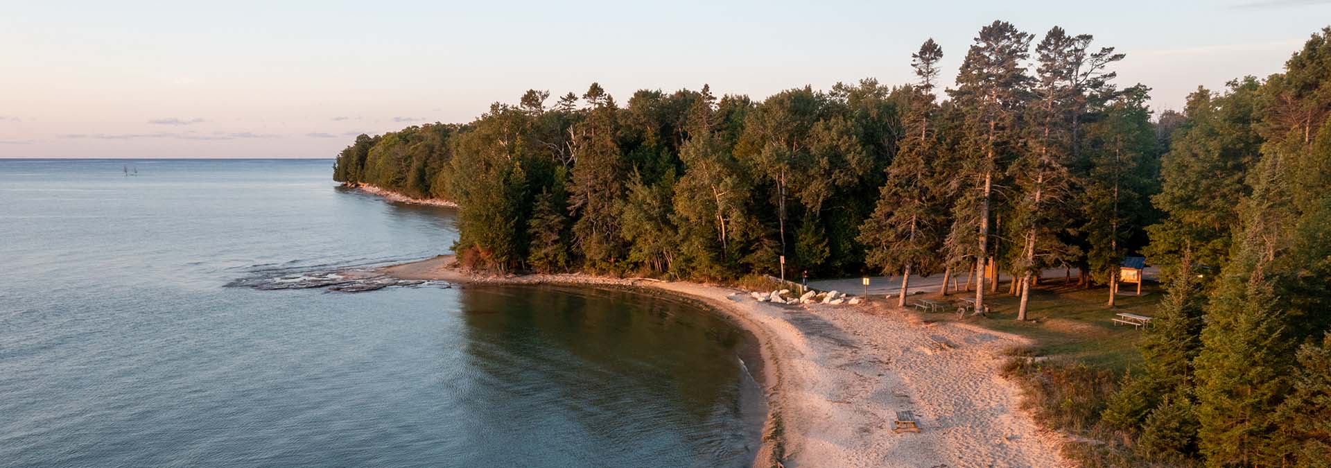 Lake Michigan with a tree-lined sandy beach shoreline.