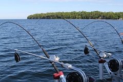 Two fishing rods in holders on the side of a boat.