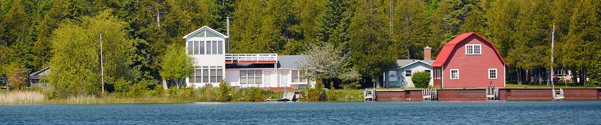 Three unique-looking rental cottages sit side by side on a crystal-blue shoreline.