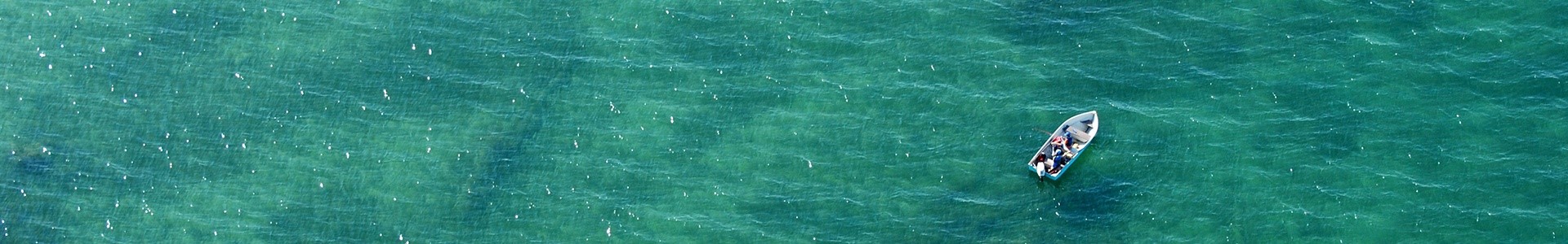 Aerial view shot of a boat floating over a shipwreck.