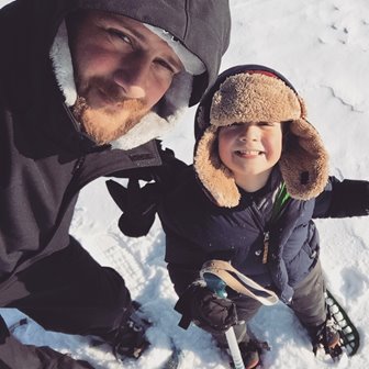 Father and son taking a selfie while snowshoeing.
