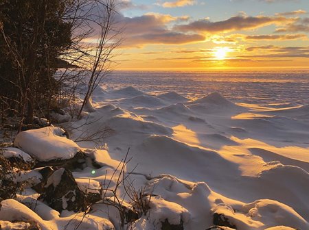 The sun rising over the snow.