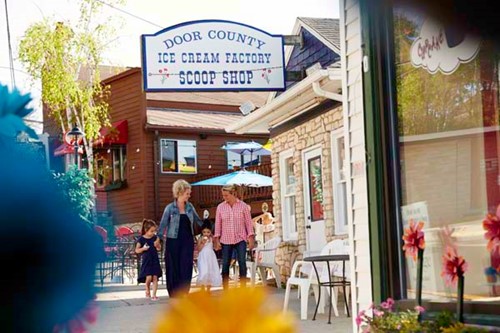 A couple with their children walk through Sister Bay and head into the Door County Ice Cream Factory.