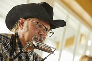 Closeup of a man playing harmonica.