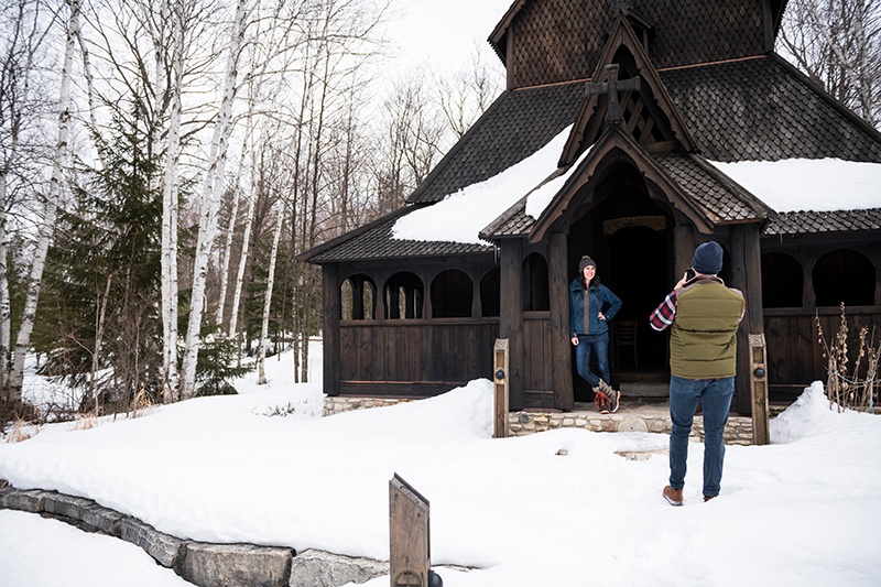 Two friends taking photos at the Stavkirke in winter