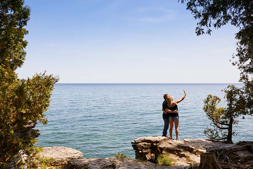 A couple takes a selfie at stunning Cave Point.